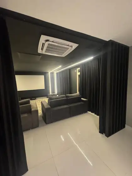 Cortina de veludo preto usada como divisória na entrada do home theater