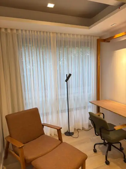 Cortina de voil branco no home office, deixando a luz natural entrar