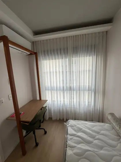 Cortina de voil branco no quarto de solteiro, instalada no recuo do teto