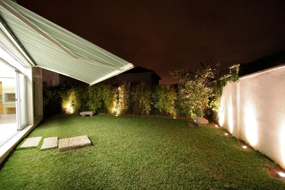 Jardim à noite com toldo com caixa