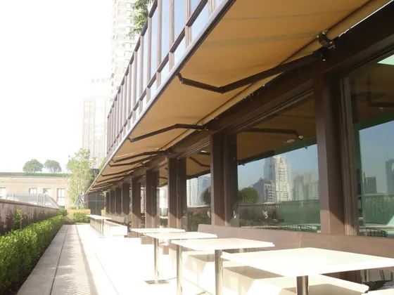 Toldo retrátil em fachada com vidro